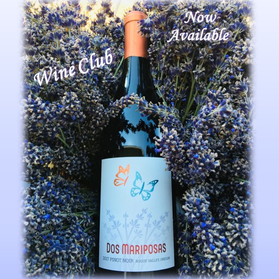 Bottle of Dos Mariposas 2017 Pinot Noir nestled in a bed of lavender. Text reads Wine Club Now Available.